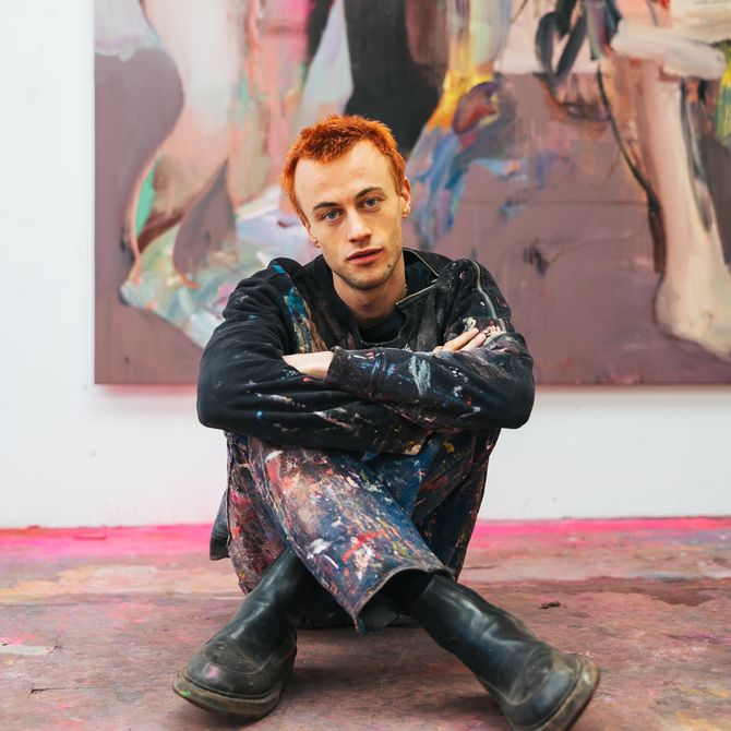 George Rouy sitting cross-legged on the floor of his studio