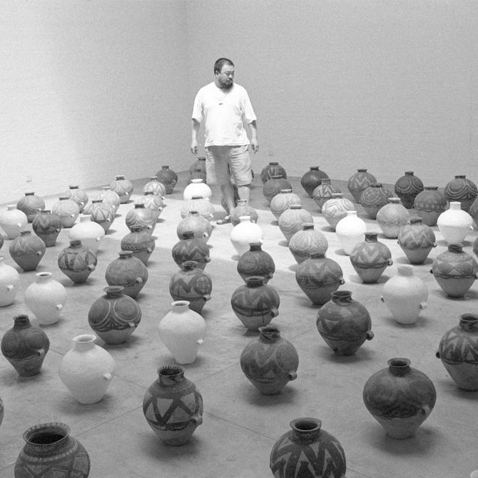 a monochrome scene of artist Ai Weiwei looking down on all his vases