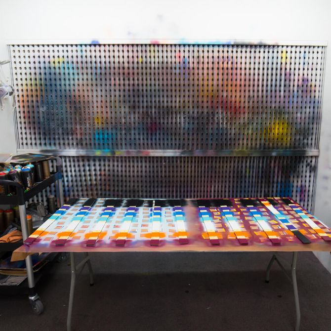 rows of colours and paints lined up on a surface in the artist's studio