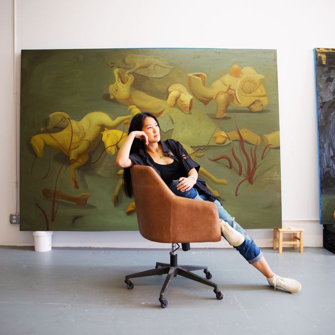 Dominique Fung reclines on a chair in her studio
