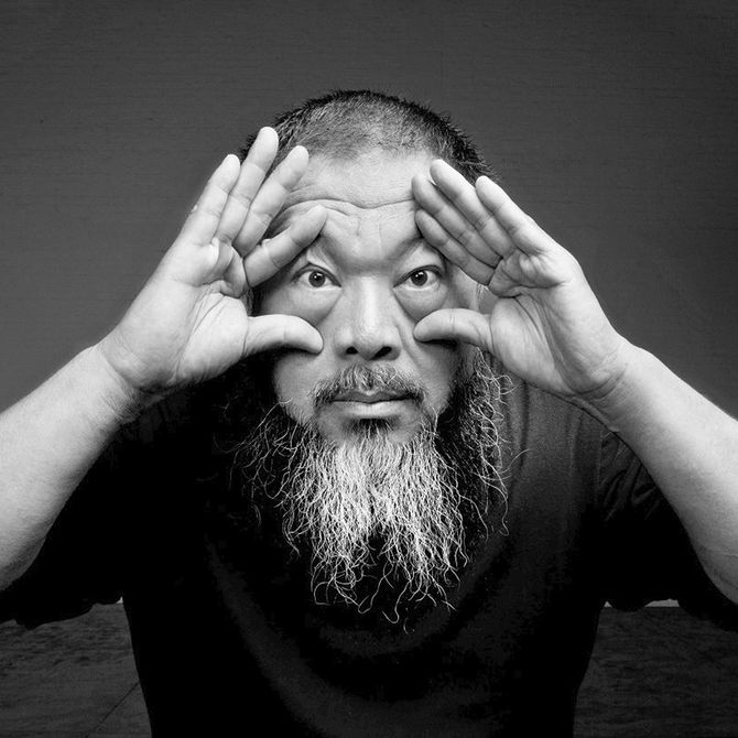 artist Ai Weiwei holding his hands to his eyes