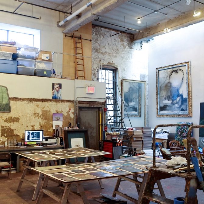double height studio space filled with eclectic paintings, statues and miscellaneous debris