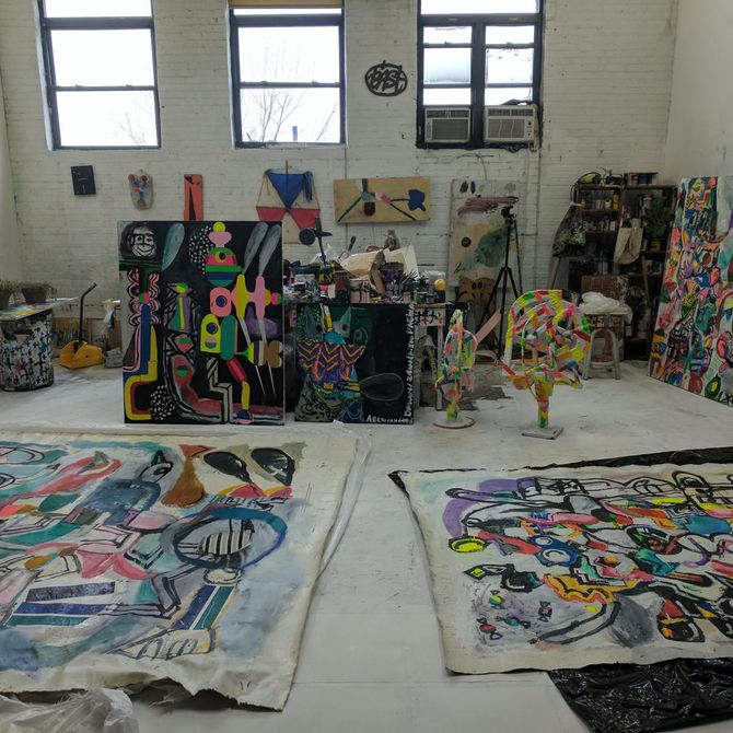 studio interior with large unstretched canvas works on the floor