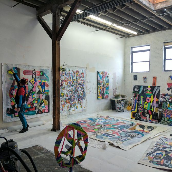 Bäst working on a large unstretched canvas painting in his studio