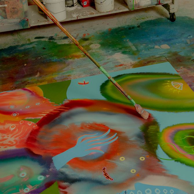 Aaron Johnson paints on the floor of studio