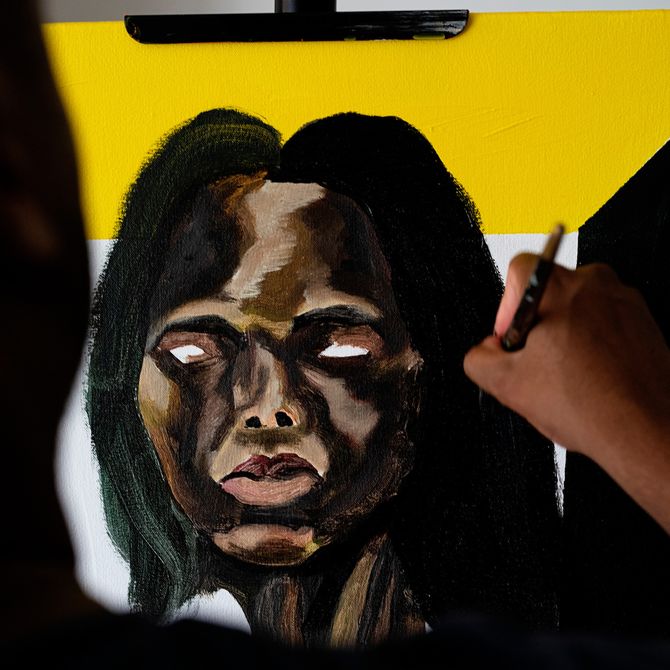 Close-up of a Marcus Brutus painting and the artist's hand as he adds details to black hair