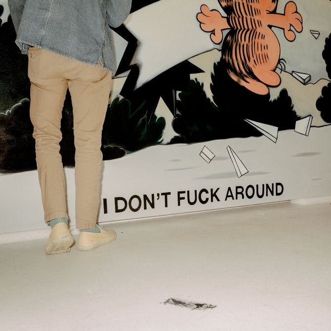 Ryan Travis Christian standing in front of his artwork