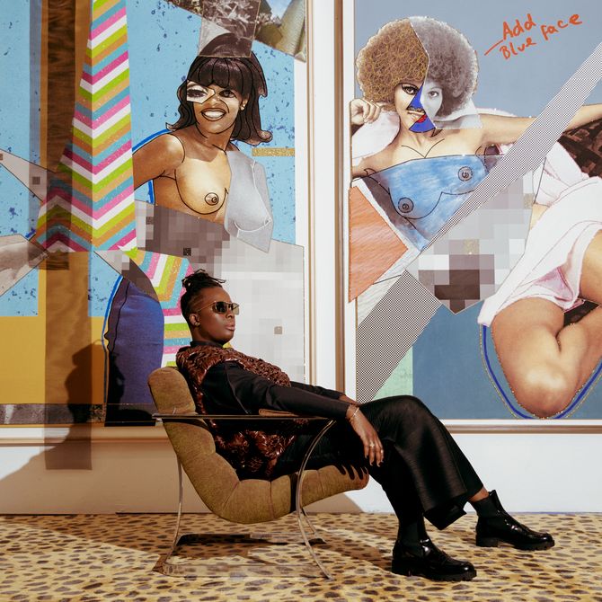 Mickalene Thomas lounging on a chair in front of two paintings 