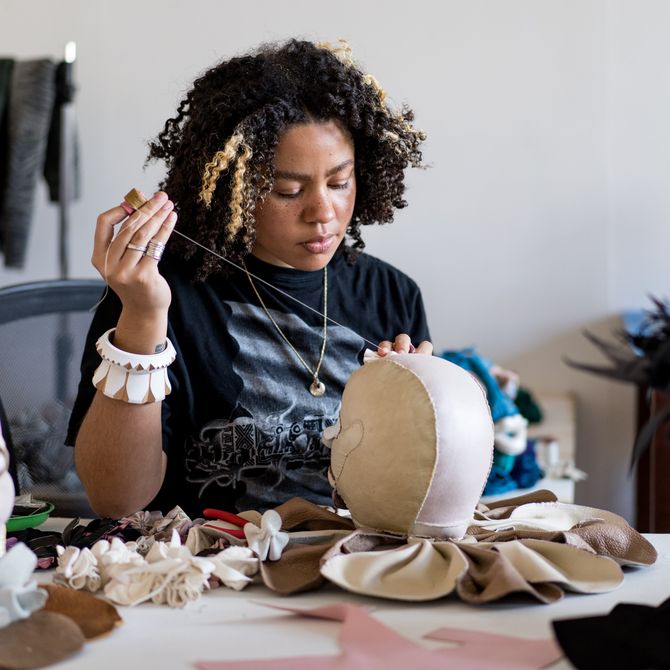 artist Tau Lewis stitching a leather sculpture at her studio