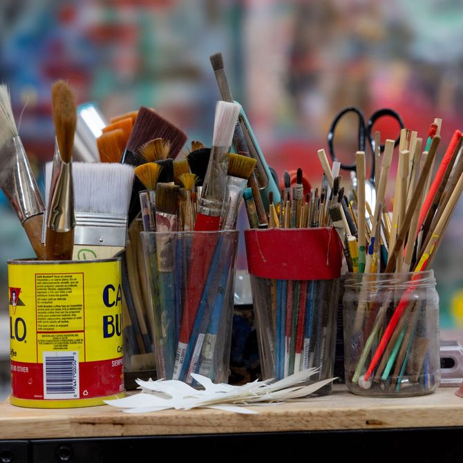 paintbrushes in pots in the artist's studio