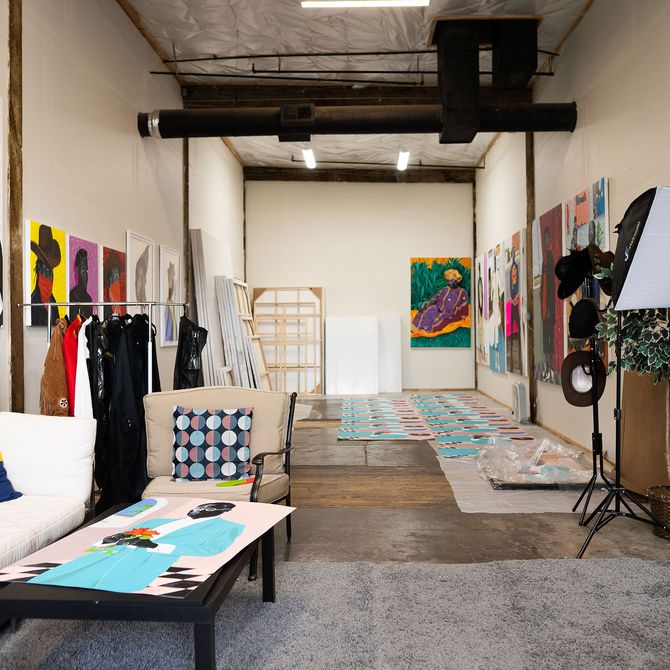 view of the artist's studio with paintings covering the walls and floor