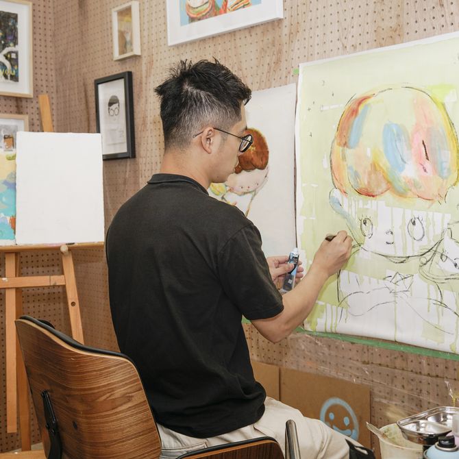 Lin-Yen Liang painting on paper on the wall in his studio