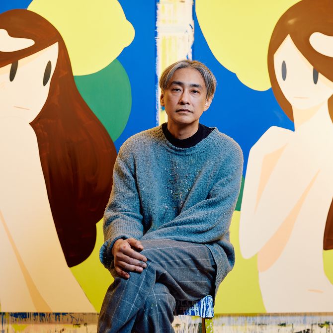 an artist sitting in his studio in front of two large scale canvases