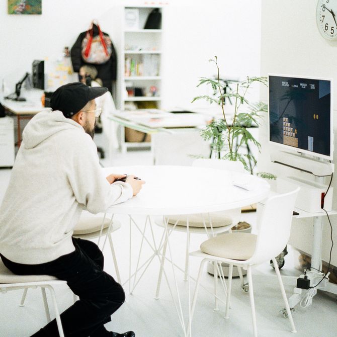 Shigeki Matsuyama sitting at a white table gaming