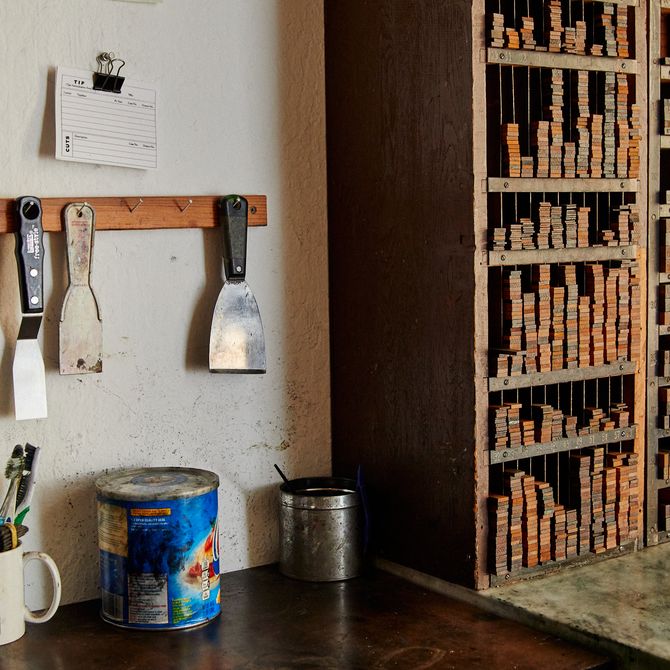 artist's studio with wooden cabinets and tools hanging from the wall