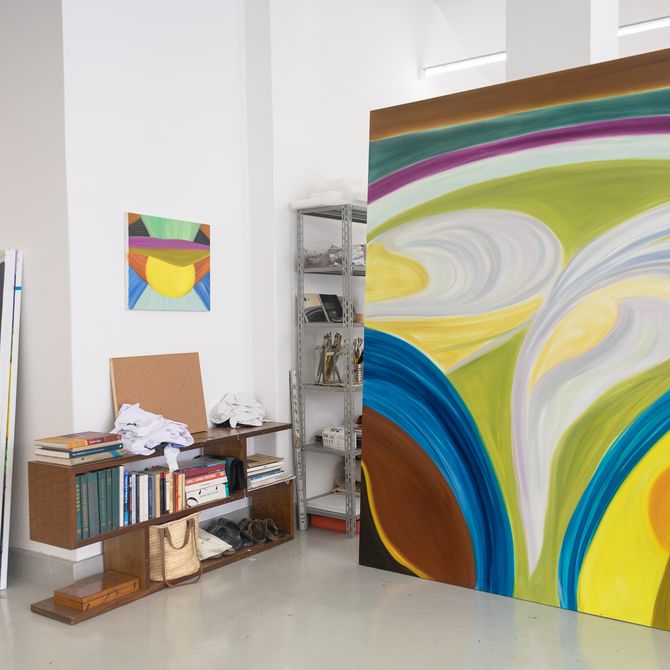 a large scale painting by Marina Perez propped up in her studio next to a cupboard of books
