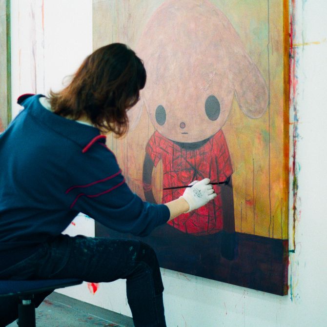 Maiko Kobayashi sitting and adding details to a painting in her studio