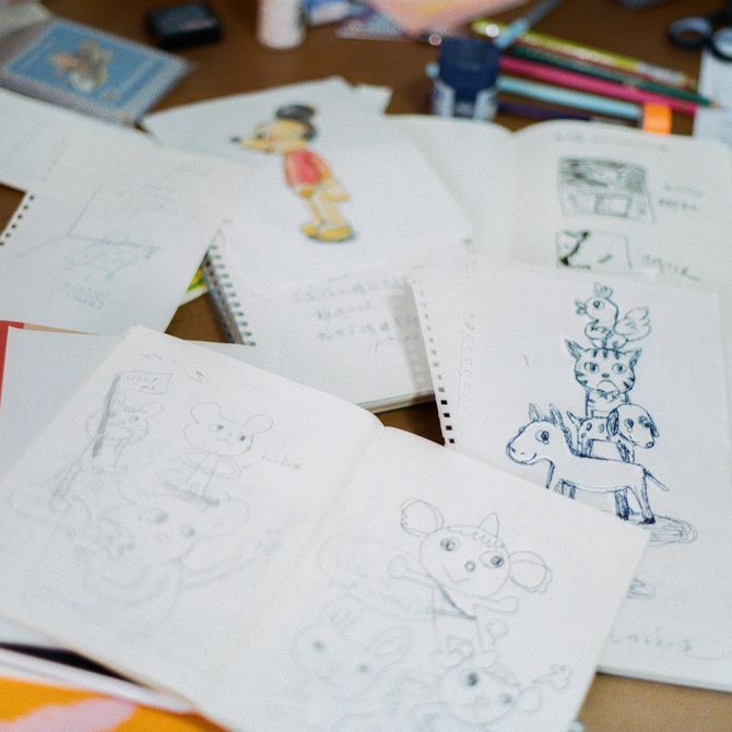 a collection of sketches piled up in the artist's studio