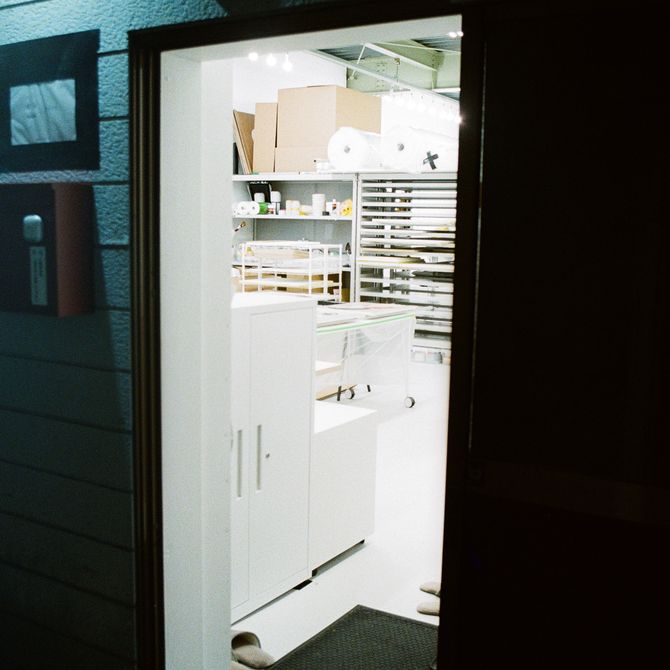 a dark doorway leading into a bright white artist studio