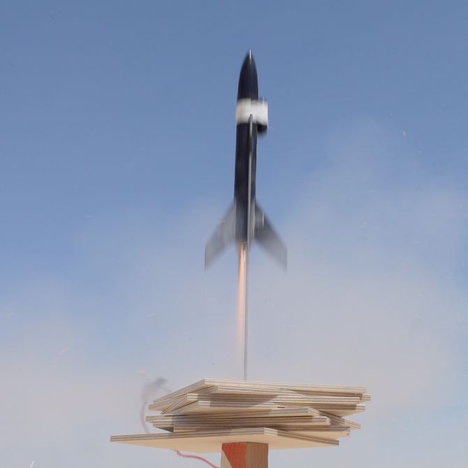 a small black rocket taking over, blurred by motion