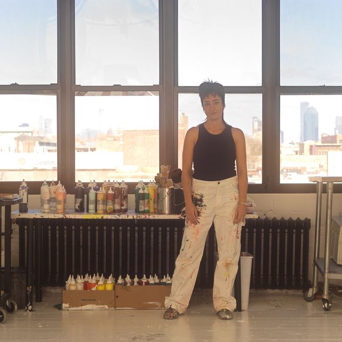 Cristina stands infront of a window in her Brooklyn appartment