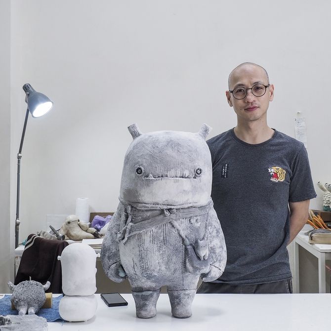 Artist A-Lei stood behind a sculpture in his studio