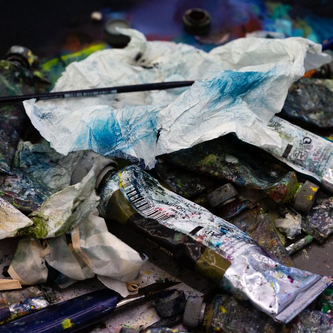 Close up of paint tubes, paint brushes and paint rags