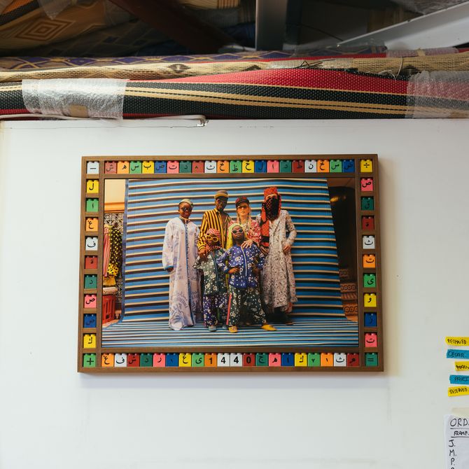 wall of artists studio with three photographs on and colourful framing