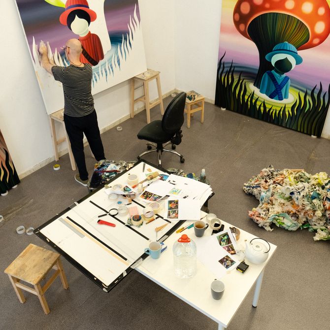 Jordi Ribes painting a canvas in his studio, surrounded by three other paintings