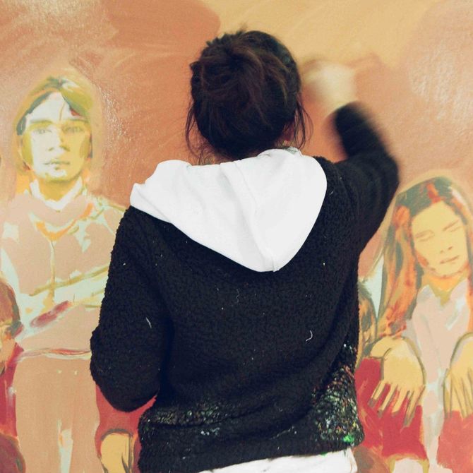 Close-up of Claire Tabouret facing a painting on which she works