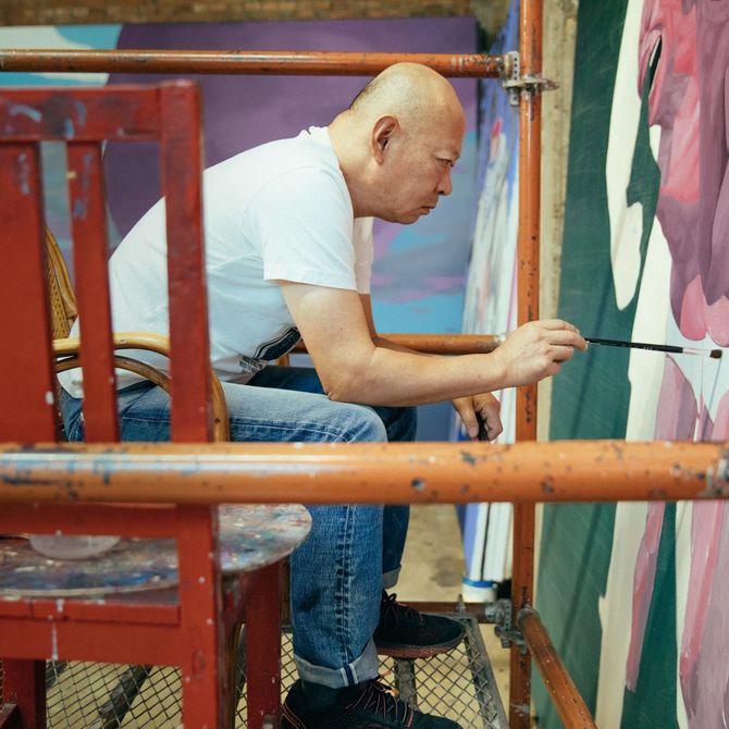 Yue Minjun concentrating on a painting 