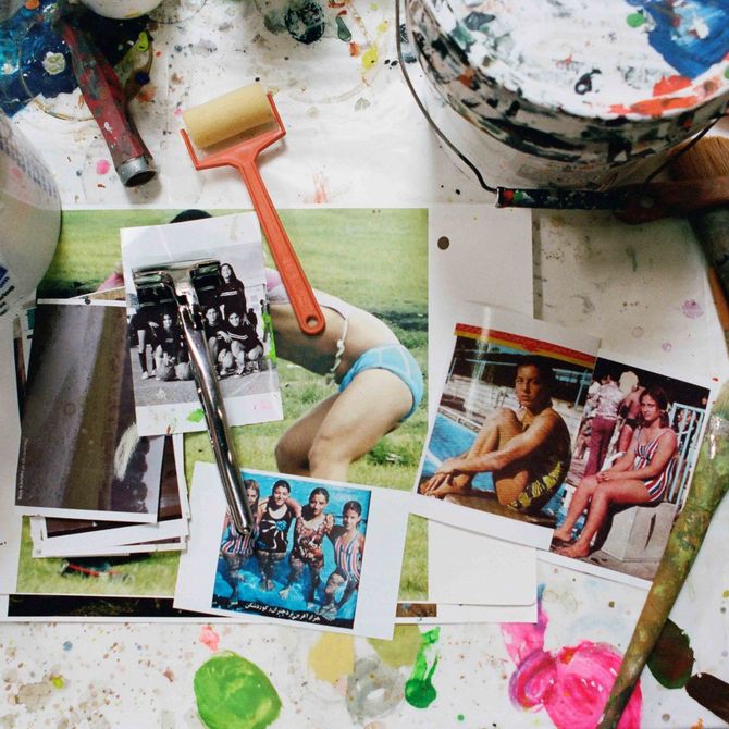 pile of photographs on a white surface with paint pots and tools