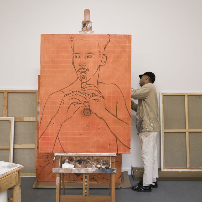 large orange painting of a male silhouette with black lines and details, resting on a large easel which the artist stands behind