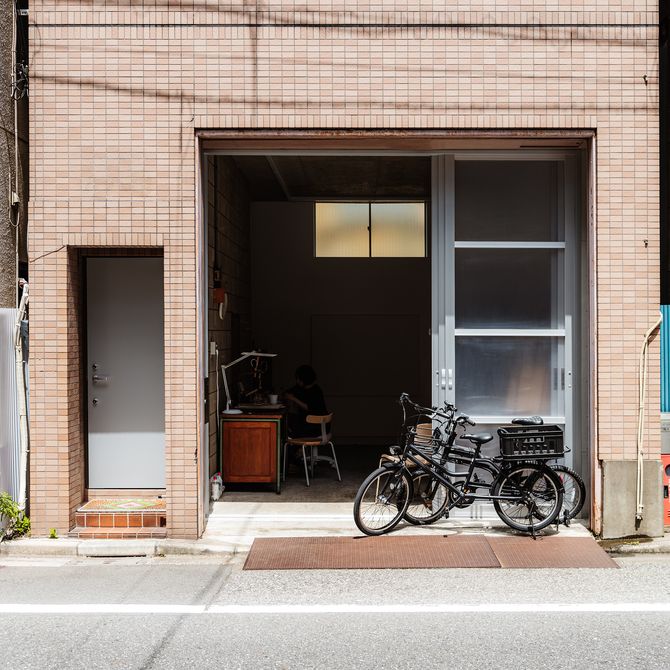 brick facade with a wide doorway and two parked black bikes