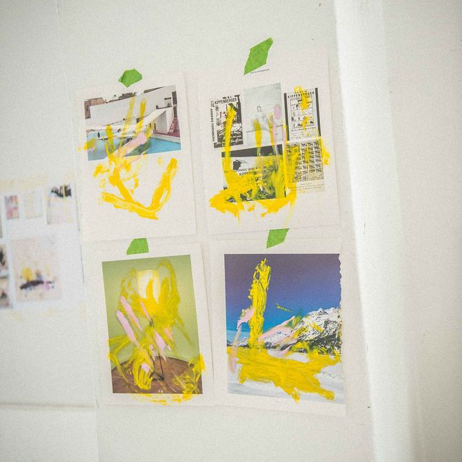 Four images stuck to a wall using green tape