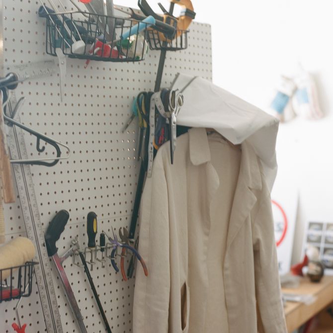 various tools hung up in the artist's studio as well as a white laboratory coat