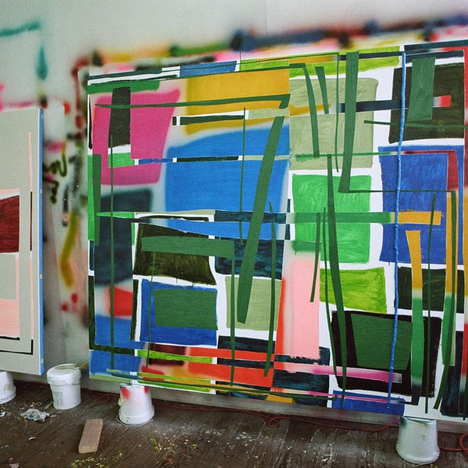 large rectangular painting balanced in the artist's studio of colour blocks and lines