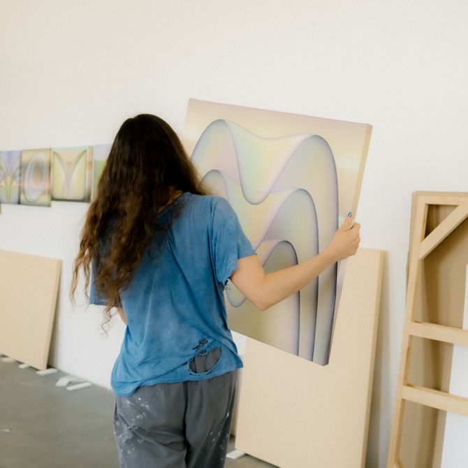 Molly moving one of her paintings to the wall
