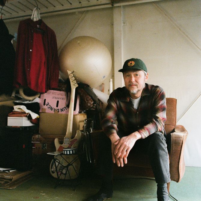 artist Tomoo Gokita sat in a chair in his studio
