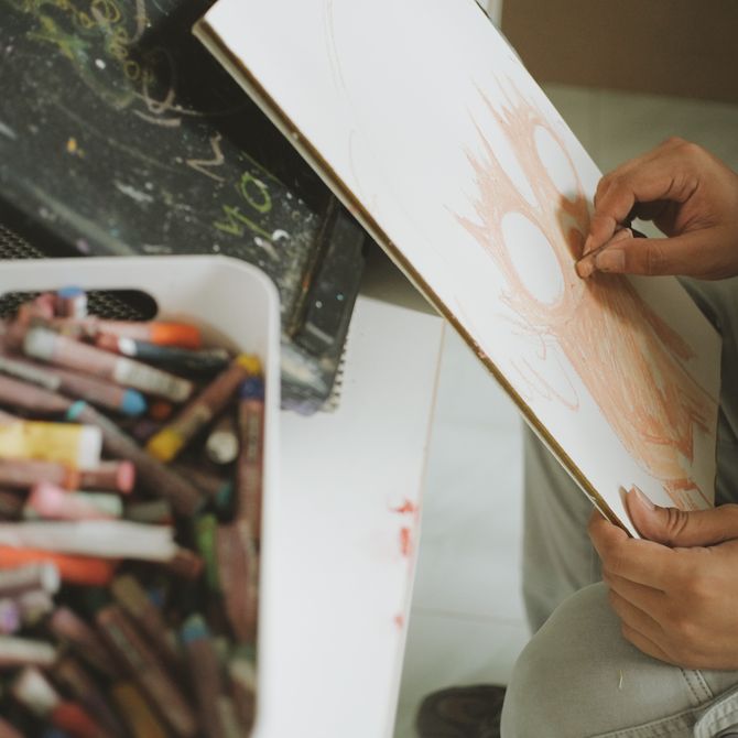 Ryol using pastels to sketch on a board