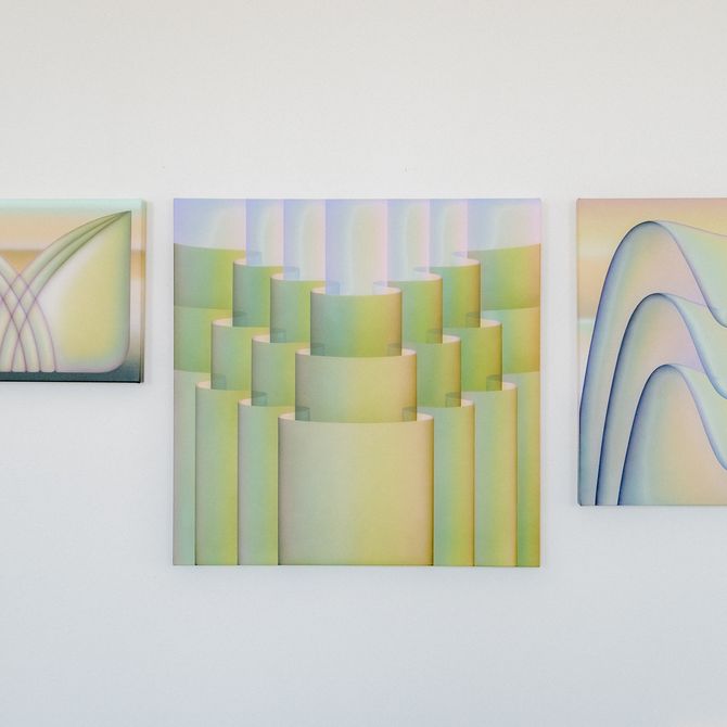Multiple paintings hung on a white wall