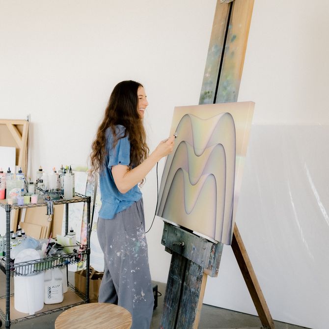 Molly Greene painting a canvas in her studio