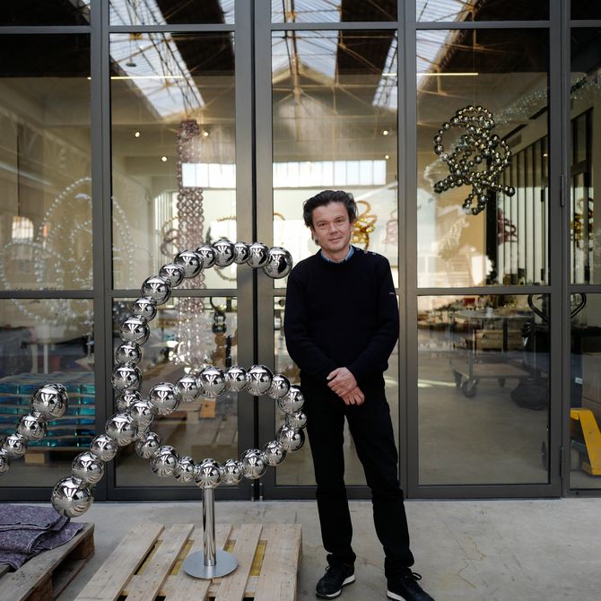 Jean Michel Othoniel stood with his artwork in his studio