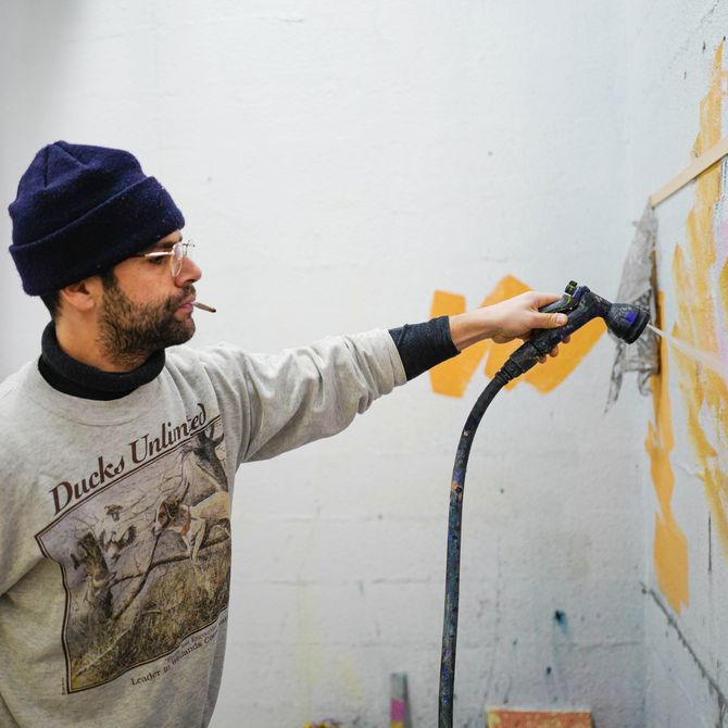 Pablo Tomek spray painting works in his studio