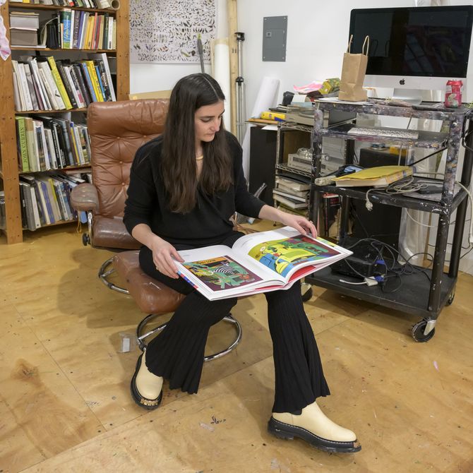 Nikki Maloof sits in studio reading book