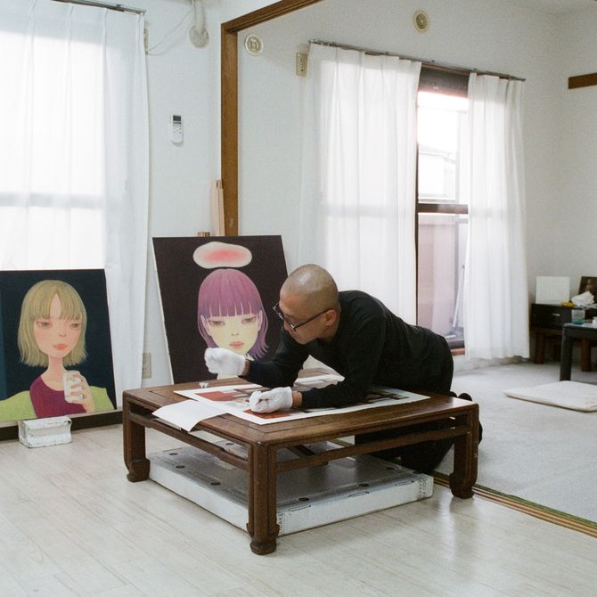 Hideaki Kawashima leaning over a low desk