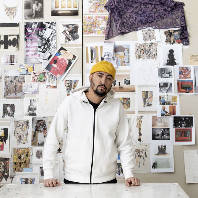 Angel Otero standing in front of a wall with sketches