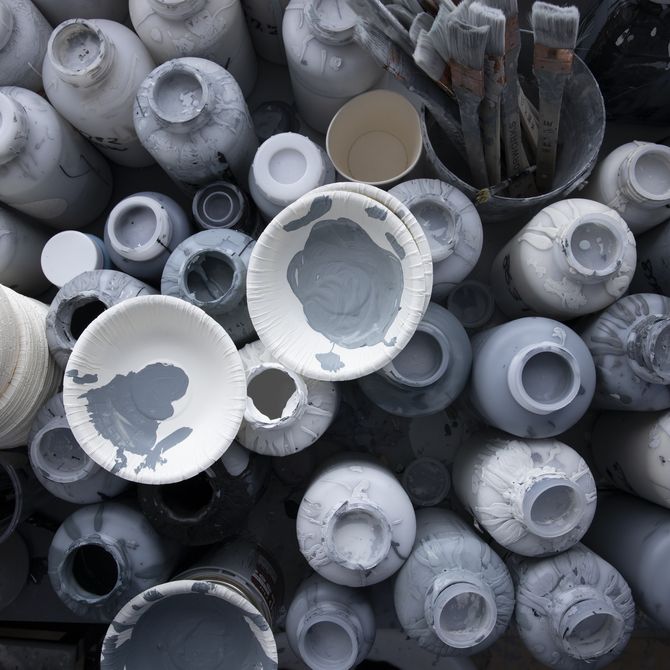 bird's eye view of various pots of paint all in different shades of white and grey