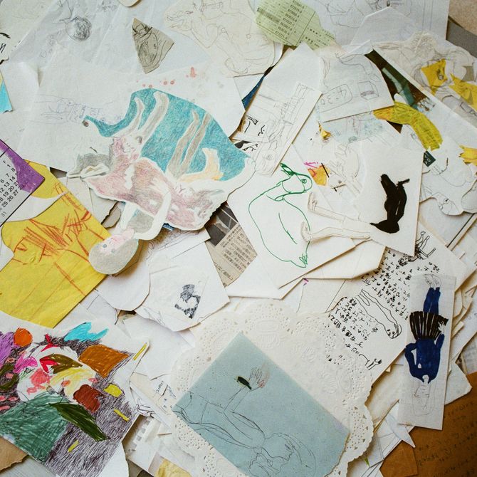 drawings and clippings overlapping one another on the floor
