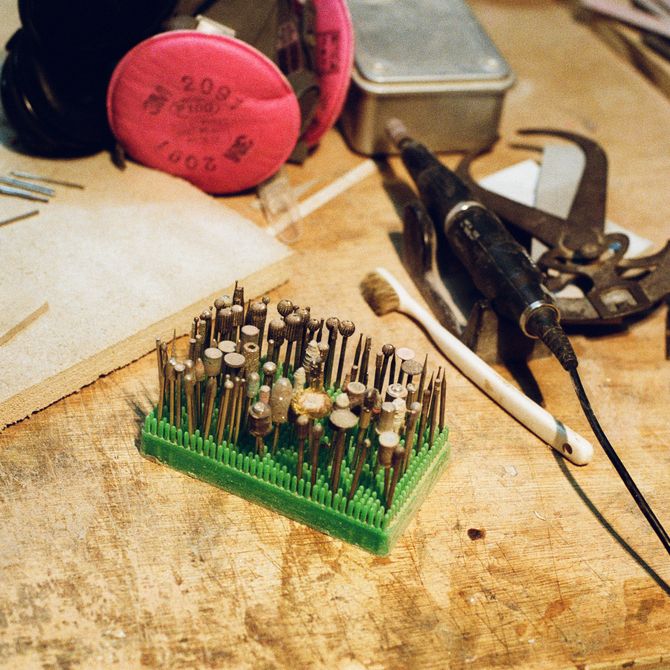 tools, nails and a plank of wood on a surface in artist's studio